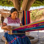 Traditional Mexican artisan weaving colorful eco-friendly fabric on backstrap loom outdoors