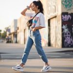 A woman wearing high-waisted mom jeans, an oversized graphic tee, and chunky sneakers in a 90s retro casual outfit