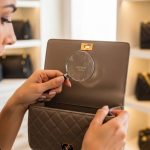 Dallas fashion enthusiast inspecting luxury purse identification marks